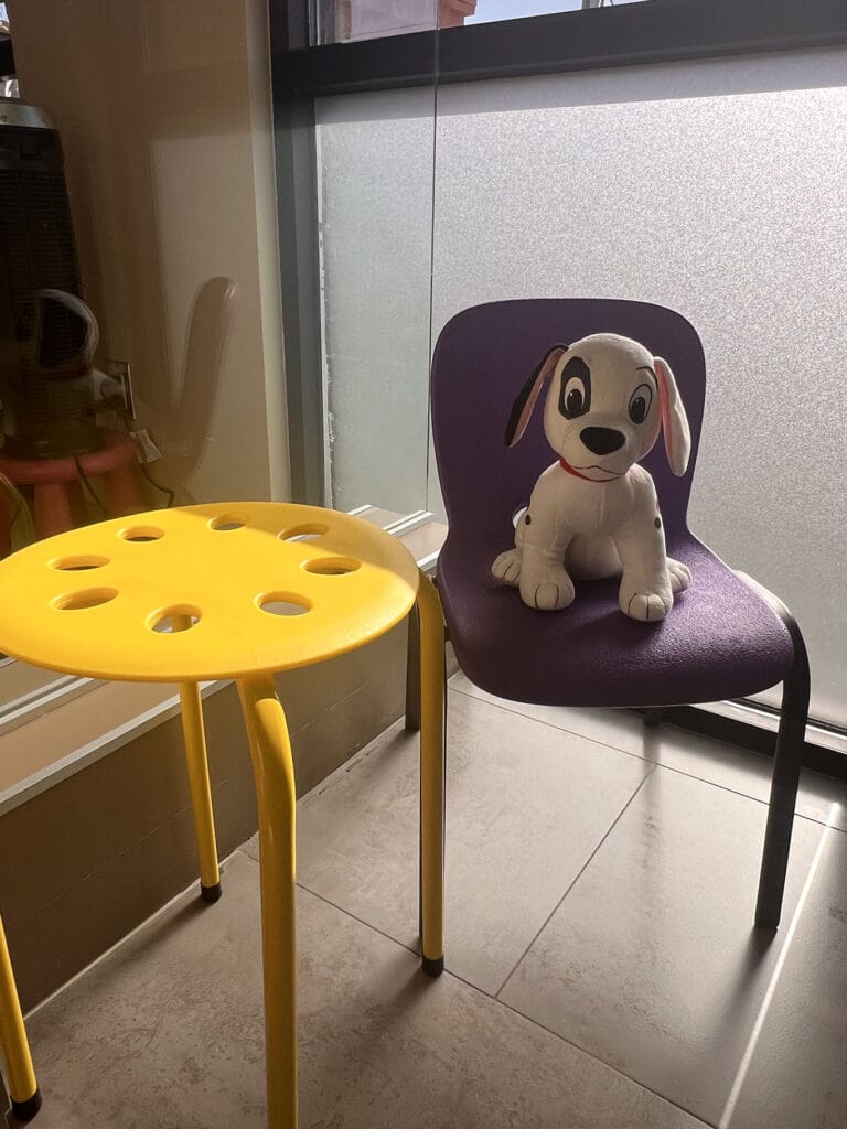 Pediatric dental treatment room at Bay Area Kids Dentistry featuring a dental chair, table, and a stuffed dog.